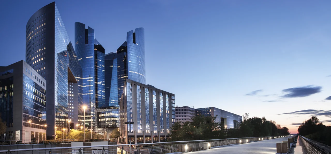 Illuminated contemporary buildings beside a waterway